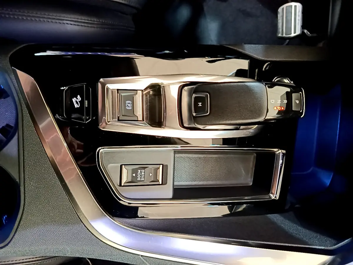 Vue rapprochée de la console centrale noire avec levier de vitesse automatique et bouton Drive Mode du Peugeot 5008 bleu.