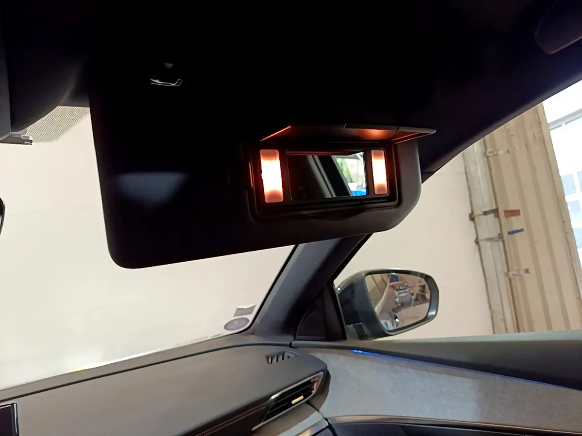 Miroir de courtoisie éclairé sur pare-soleil côté passager intérieur d’un Peugeot 5008 bleu, vue latérale droite.