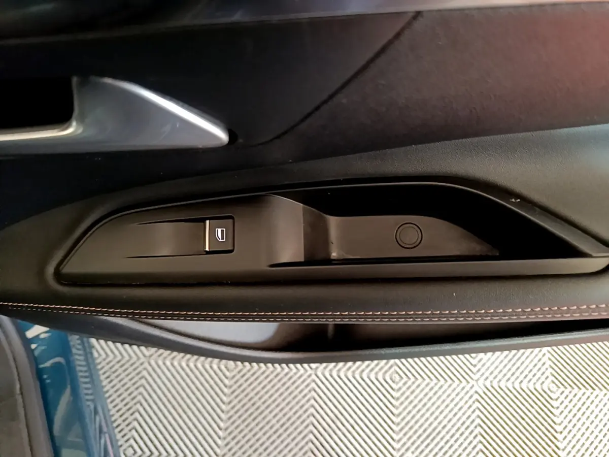 Gros plan sur la commande de lève-vitre côté gauche avec surpiqûres marron, Peugeot 5008 bleu 2021.