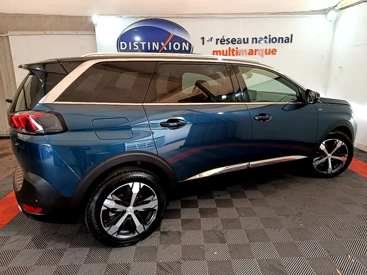 Vue latérale droite d'un Peugeot 5008 bleu 2021 avec toit blanc et jantes alliage distinctives.