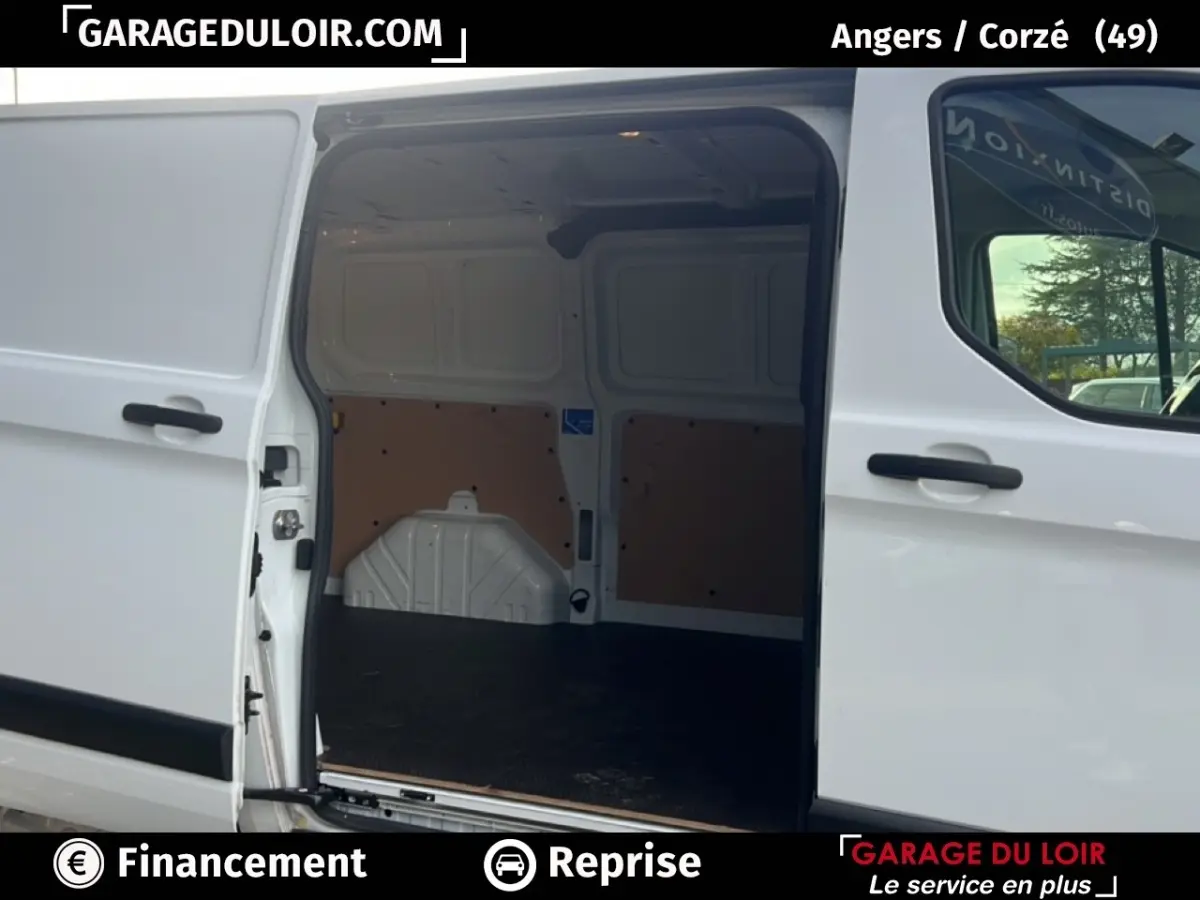 Vue latérale du Ford Transit Custom blanc 2023 avec porte coulissante ouverte montrant l’espace de chargement vide.