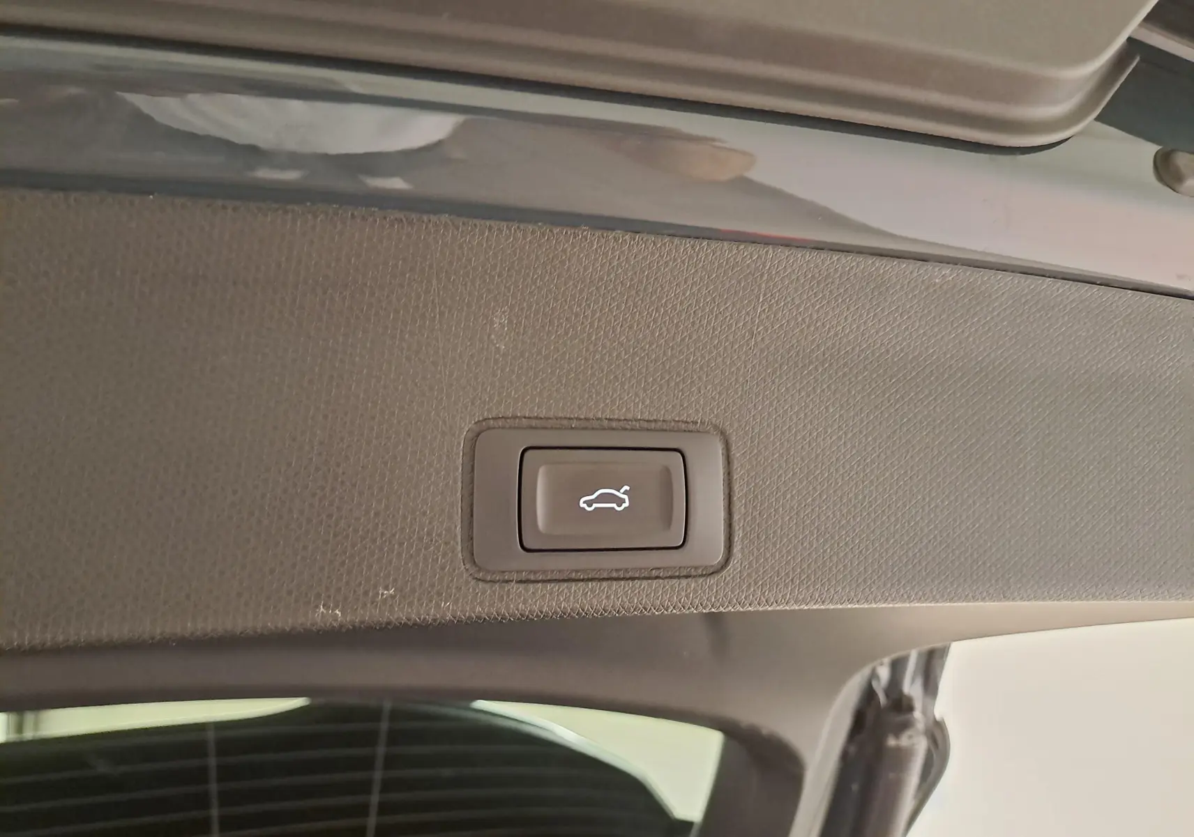 Bouton d'ouverture électrique du coffre sur la partie intérieure du hayon d'un CUPRA TERRAMAR bleu Fjord.