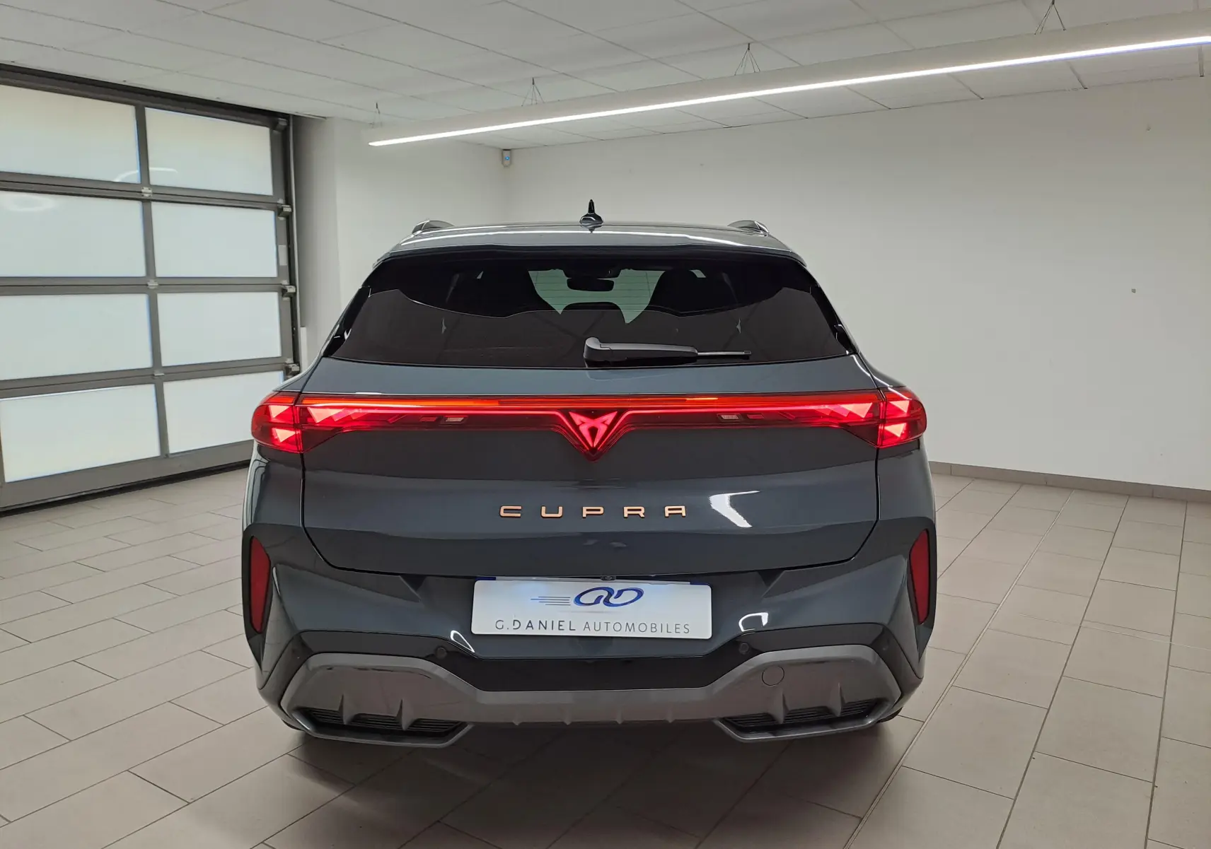 Vue arrière du CUPRA TERRAMAR bleu Fjord 2025 avec feux LED continus et logo CUPRA lumineux au centre.