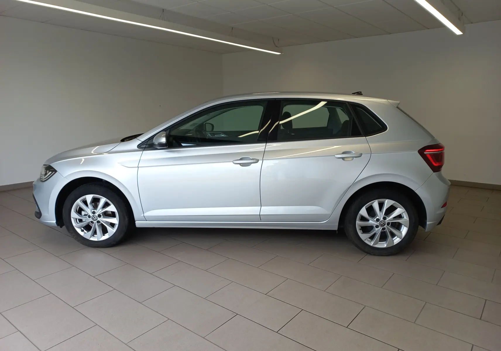 Volkswagen Polo 1.0 TSI 95 DSG7 Style en reflet d'argent vue de profil côté gauche dans un intérieur neutre.