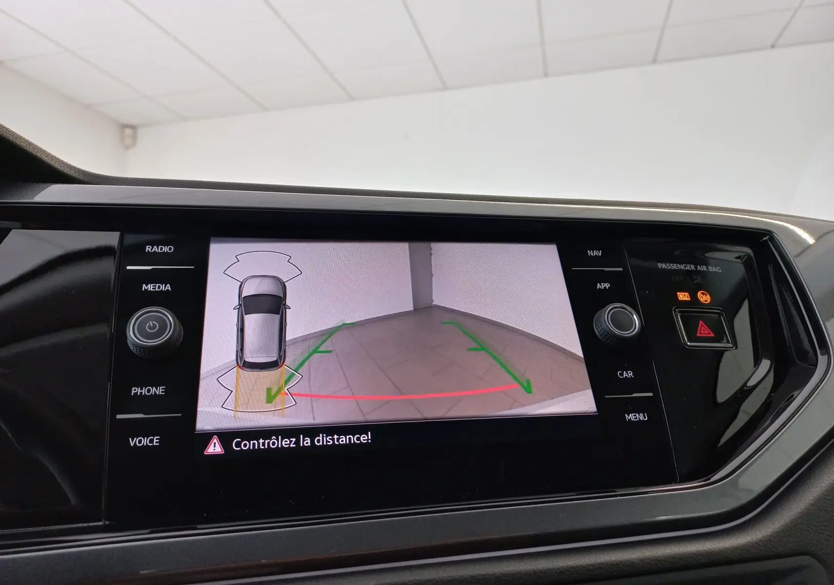 Écran de caméra de recul affichant la zone arrière d'une Volkswagen Polo 2026 en intérieur, avec guidage de trajectoire.