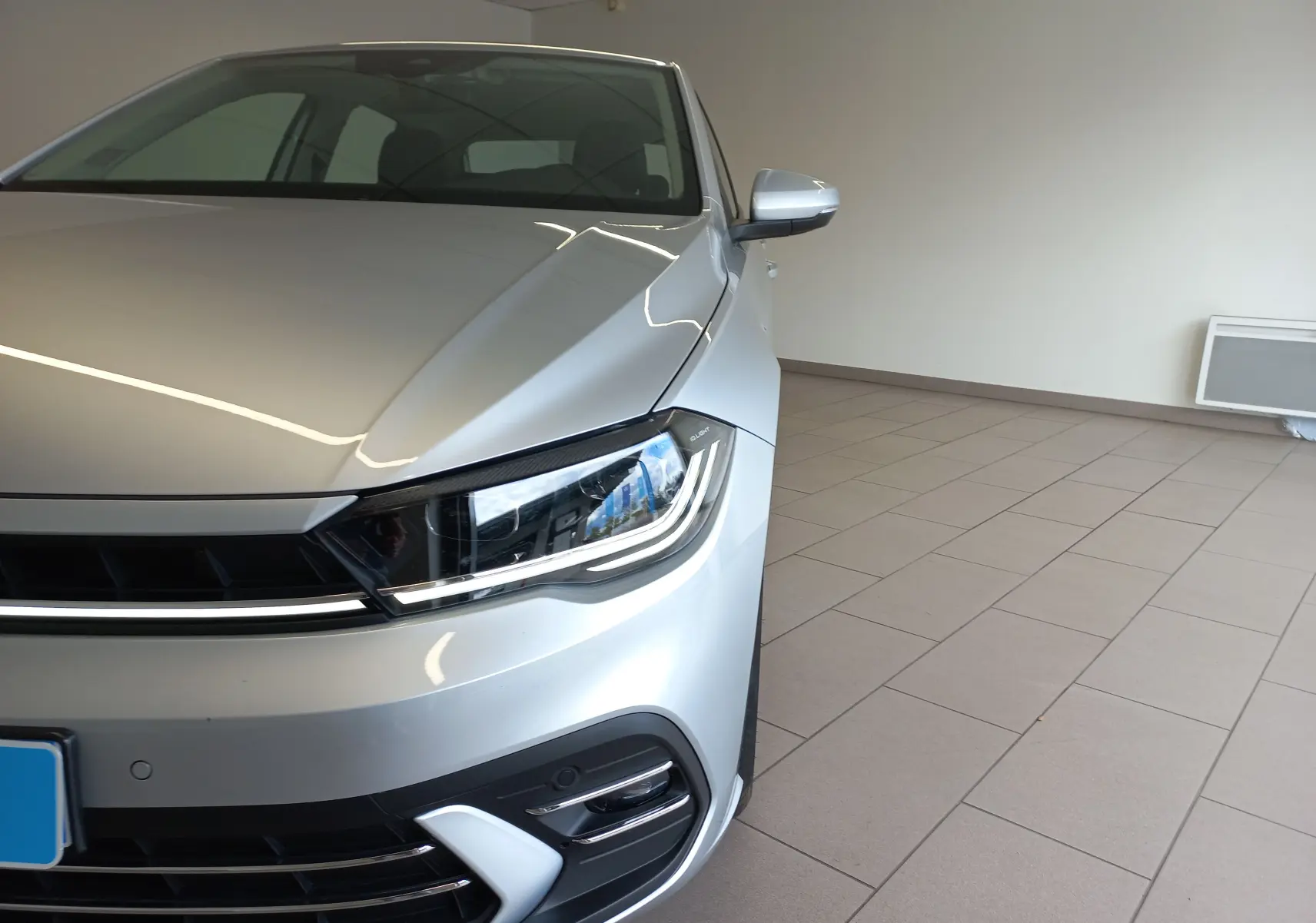 Vue 3/4 avant droit d'une Volkswagen Polo 2026 argentée mettant en valeur son phare LED et sa calandre moderne.