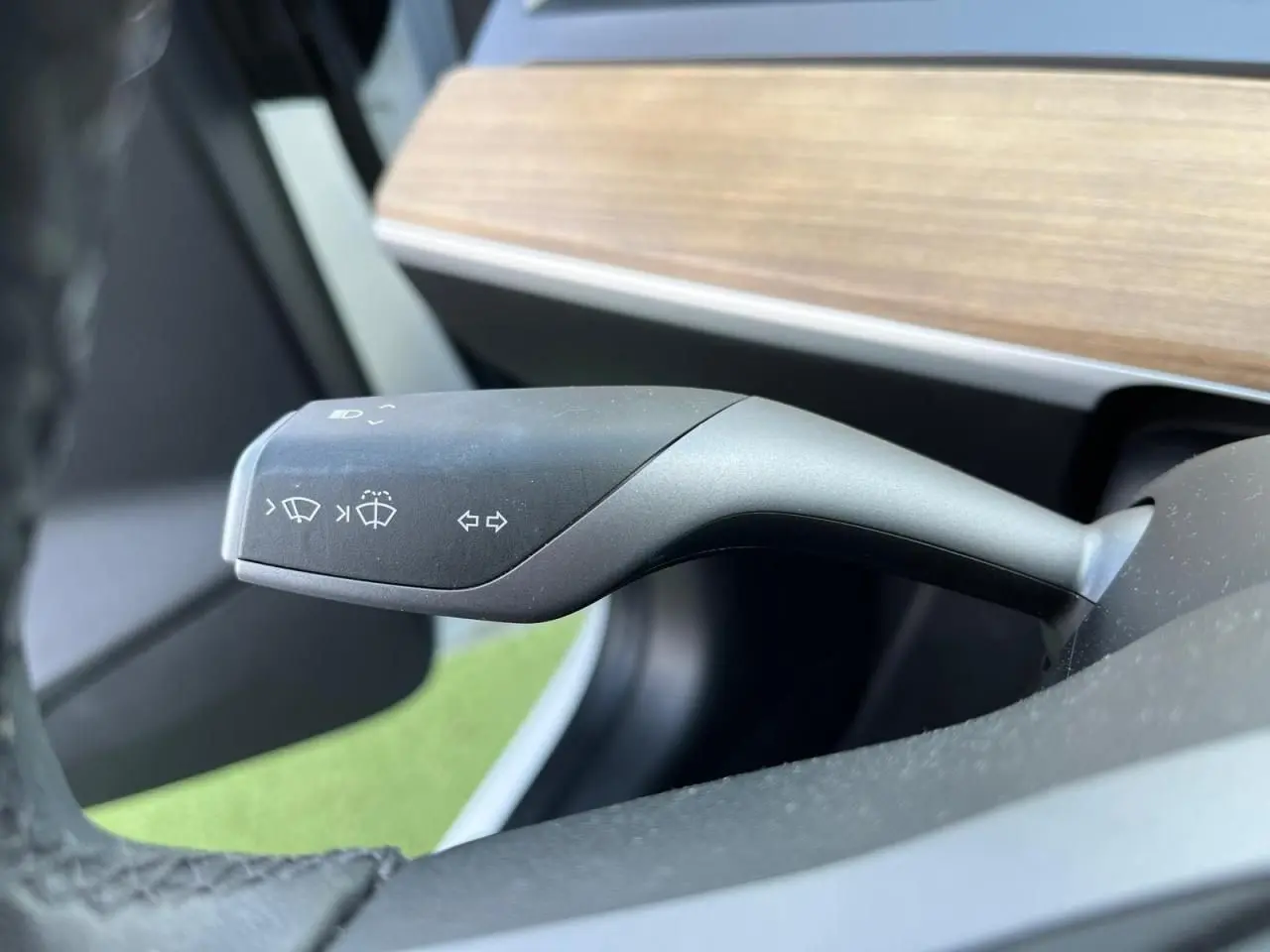 Le commodo de clignotants et essuie-glaces de la Tesla Model 3 Standard Plus RWD 2022, intérieur noir avec tableau de bord bois.