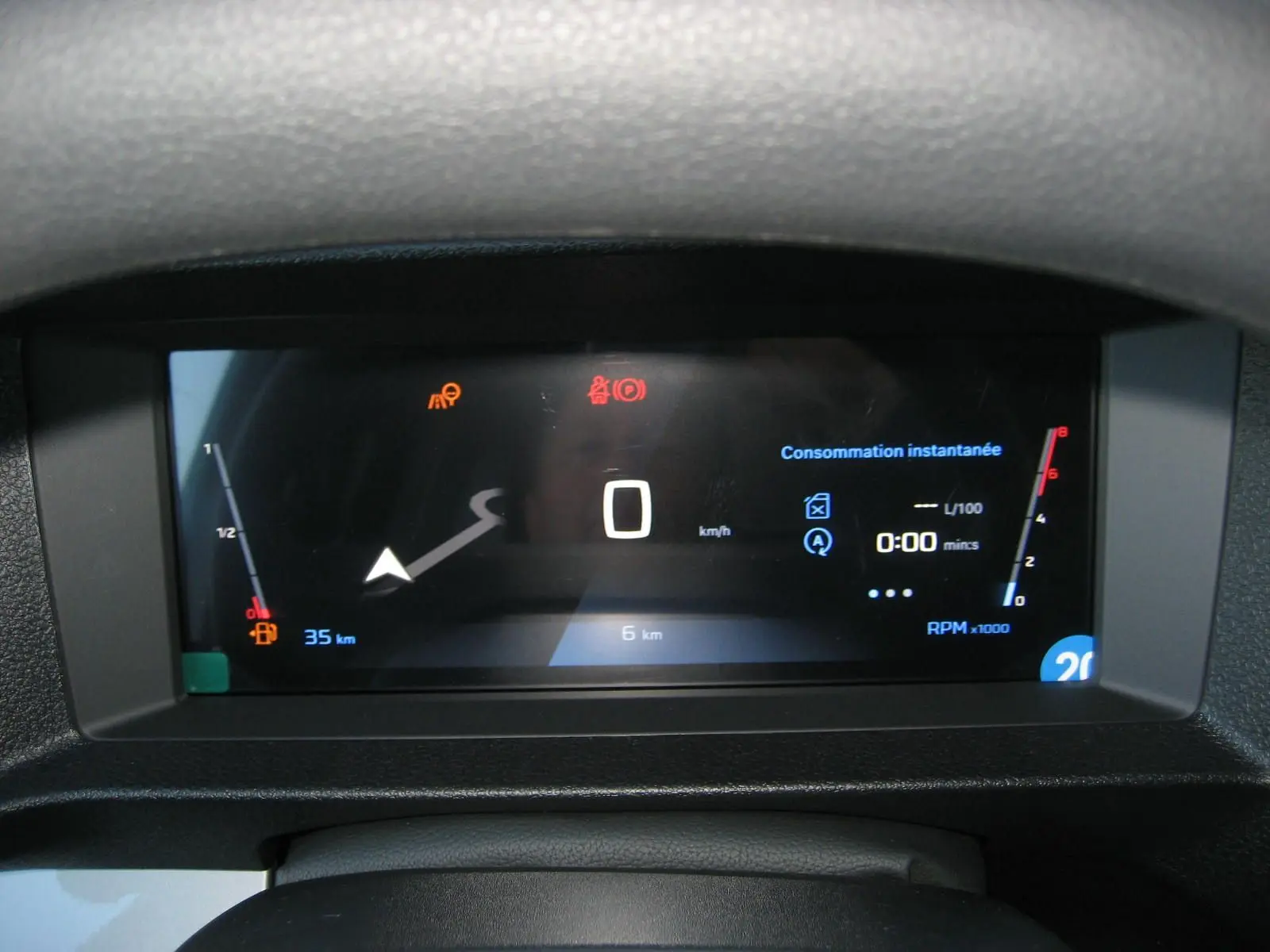 Affichage numérique du tableau de bord du Peugeot Expert Fourgon blanc 2025, montrant la consommation instantanée et le compteur à zéro km/h.