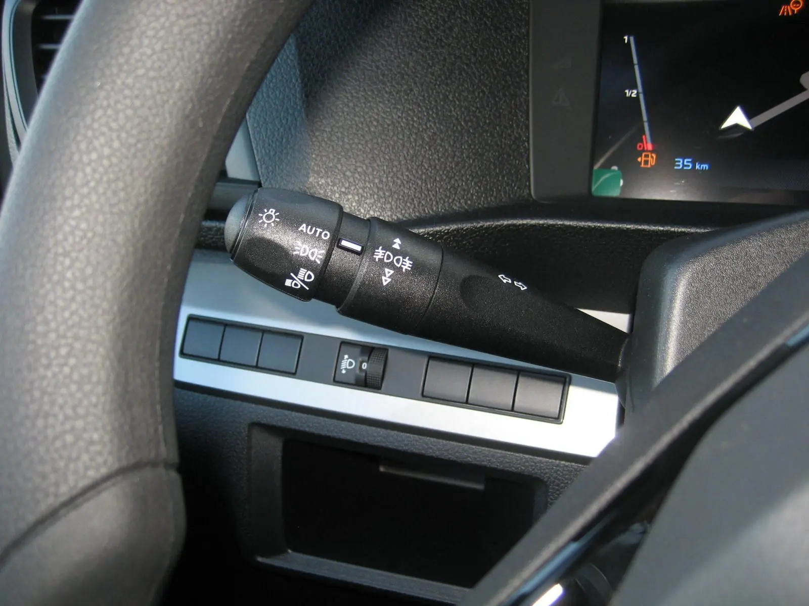 Gros plan sur la manette des feux et clignotants à gauche du volant dans l'habitacle du Peugeot Expert Fourgon blanc.