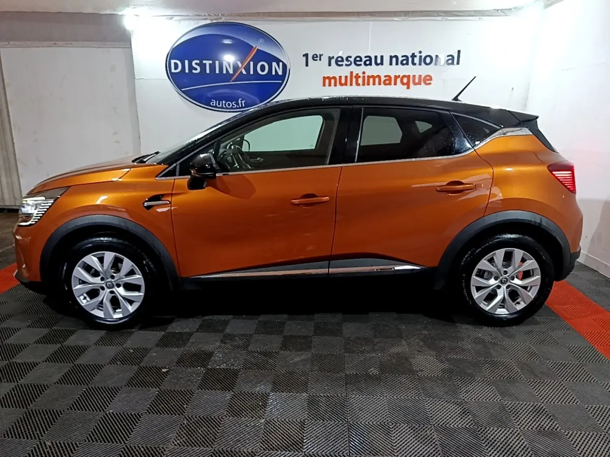 Profil droit d'un Renault Captur Intens 2020 orange métallisé avec toit noir, jantes alliage et rétroviseurs noirs.