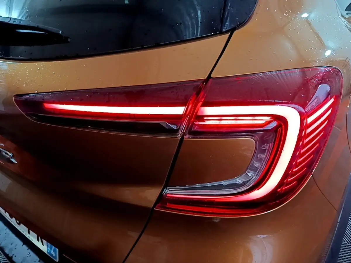 Feu arrière droit allumé d’un Renault Captur jaune 2020, vue rapprochée sous la pluie.