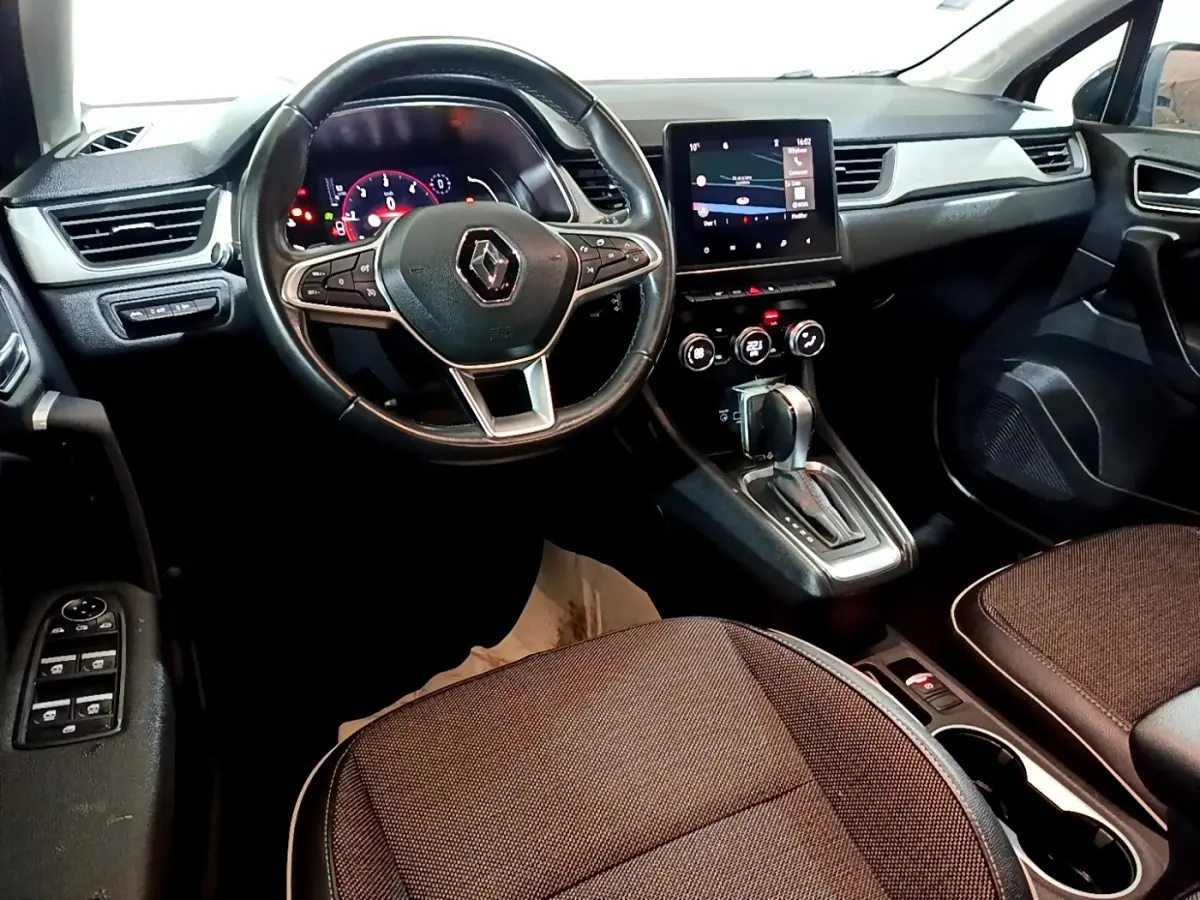 Vue intérieure côté conducteur du tableau de bord noir et volant cuir du Renault Captur Intens 2020.