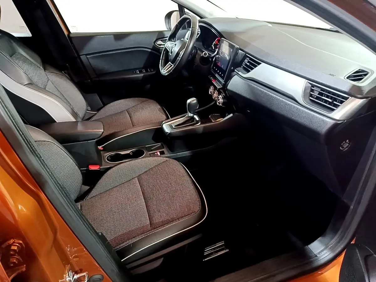 Intérieur avant droit du Renault Captur Intens 2020, sièges gris, tableau de bord avec écran tactile vertical.