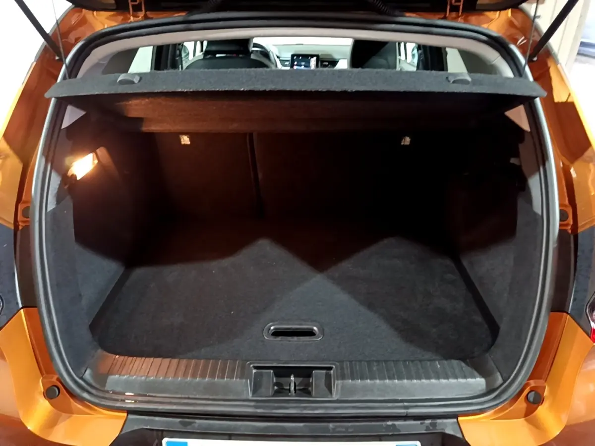 Coffre ouvert vu de l'arrière d'un Renault Captur jaune, montrant l'espace de chargement vide et la tablette cache-bagages.