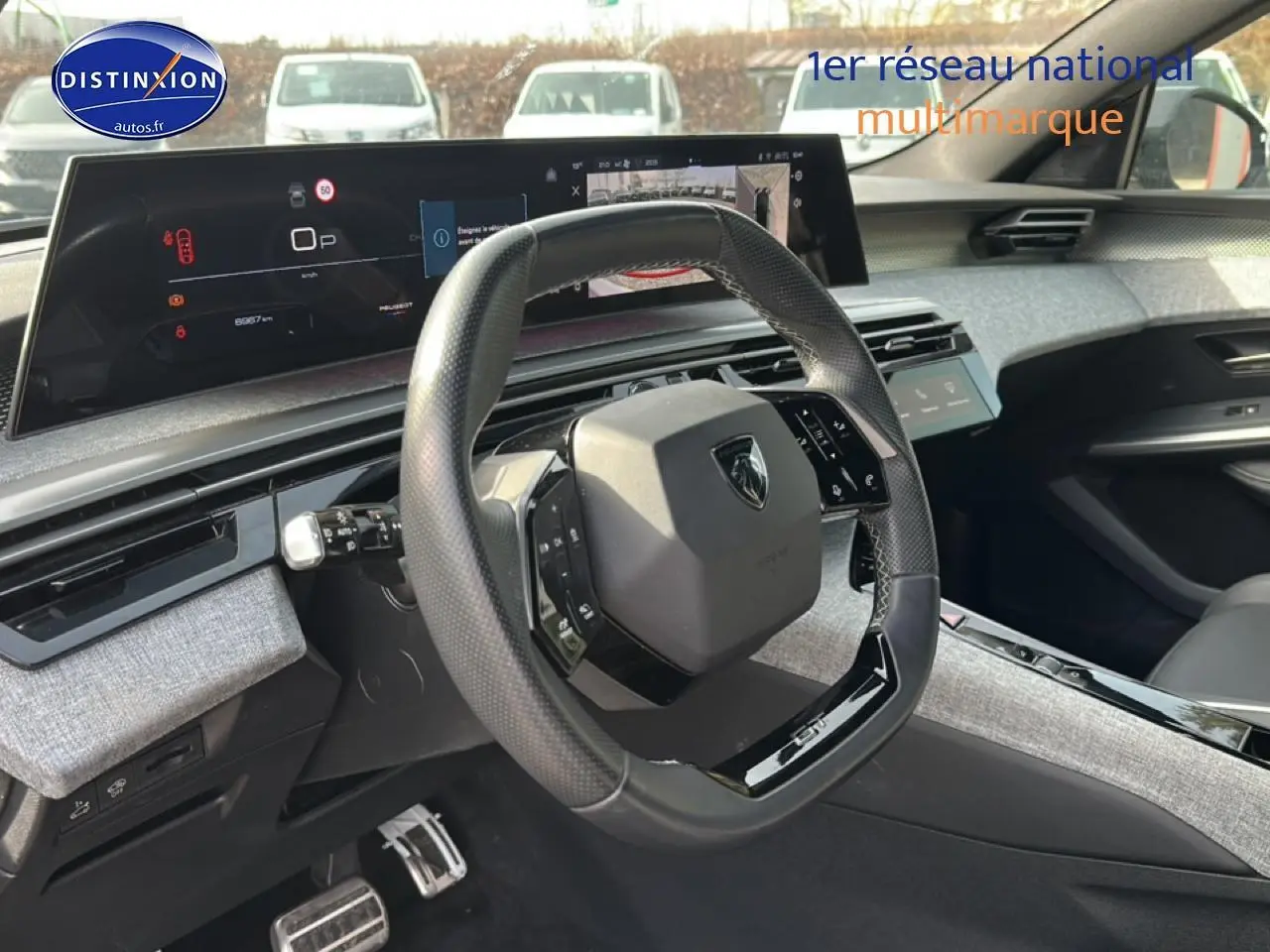 Vue intérieure côté conducteur du Peugeot 3008 gris Artense avec volant multifonction et tableau de bord numérique large.