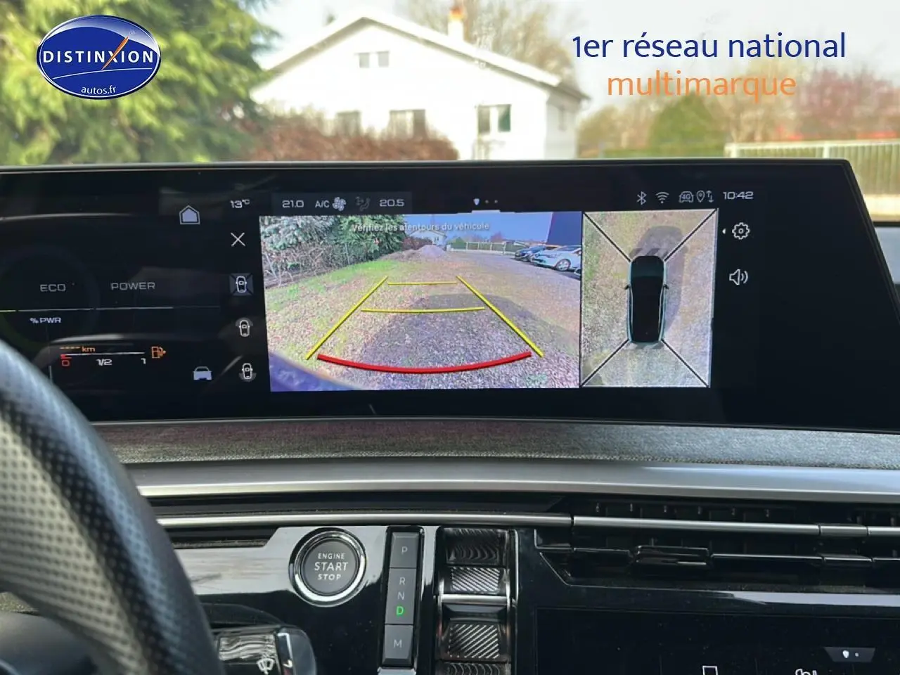 Vue intérieure du tableau de bord du Peugeot 3008 2025 avec écran tactile affichant la caméra de recul et commandes autour du bouton start/stop.