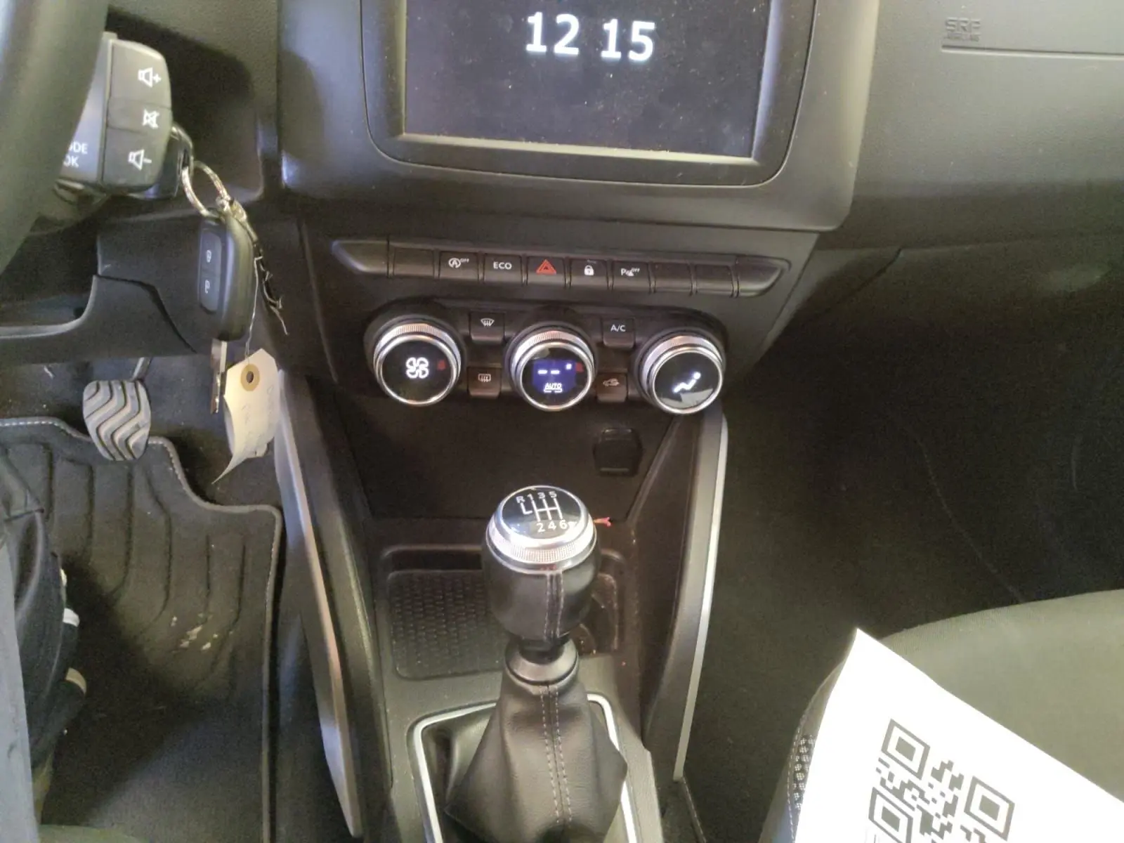 Vue intérieure centrée sur la console centrale et levier de vitesses manuel du Dacia Duster 2021, détails des commandes climatisation visibles.