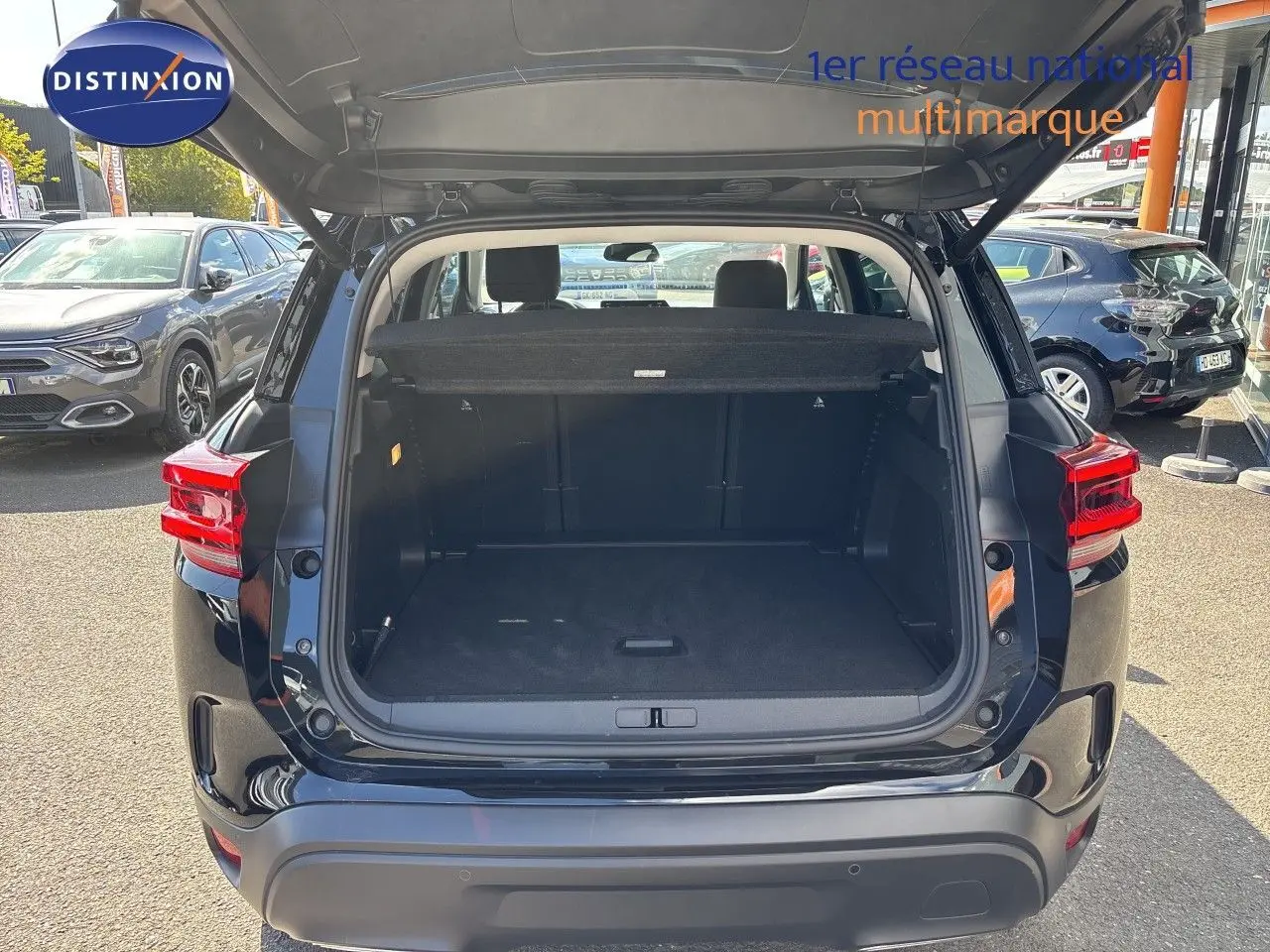 Vue arrière du Citroën C5 Aircross noir Perla Nera avec coffre ouvert, montrant un espace de chargement spacieux.