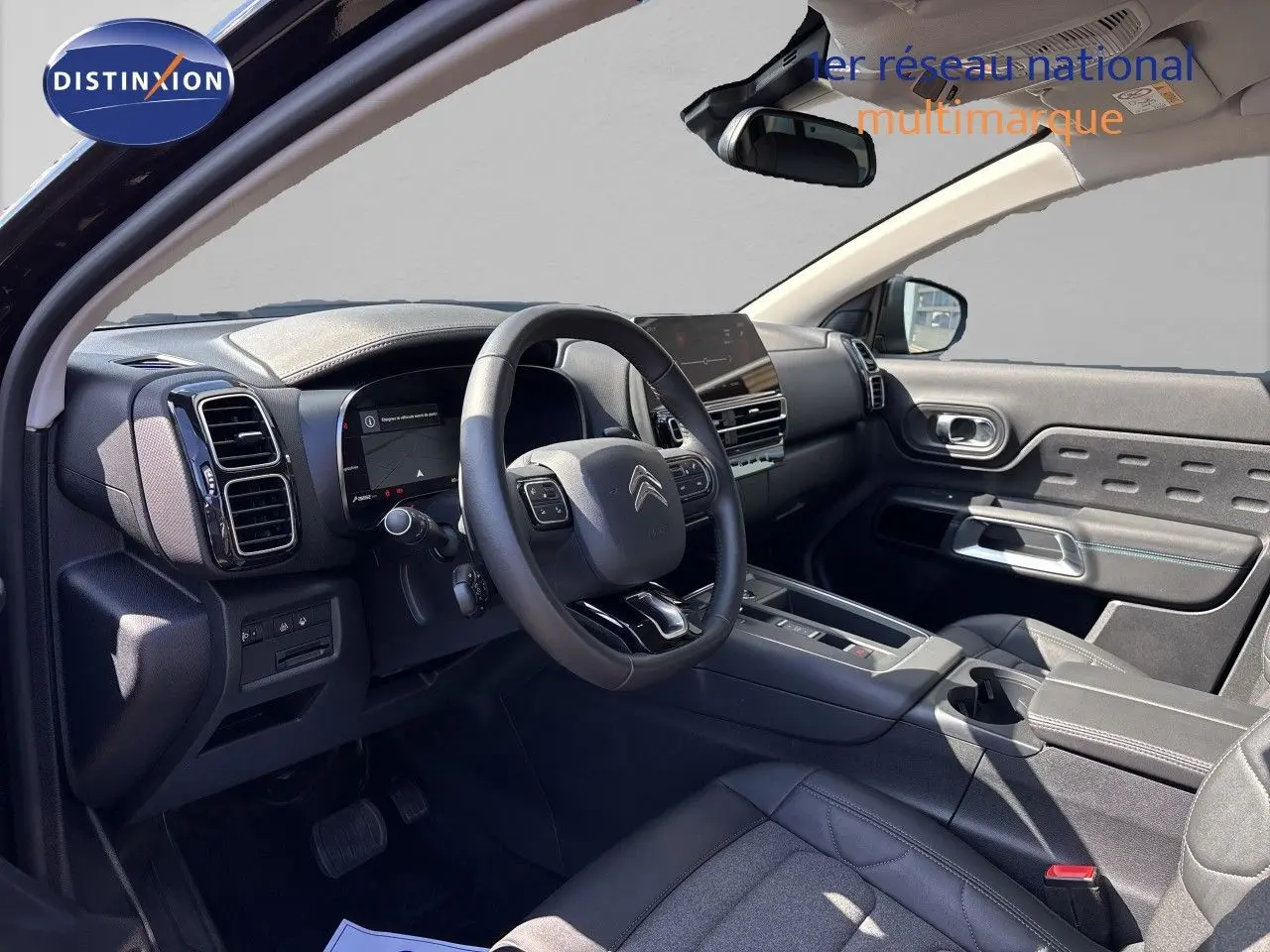 Vue intérieure côté conducteur du Citroën C5 Aircross noir Perla Nera, avec tableau de bord moderne et volant multifonction.