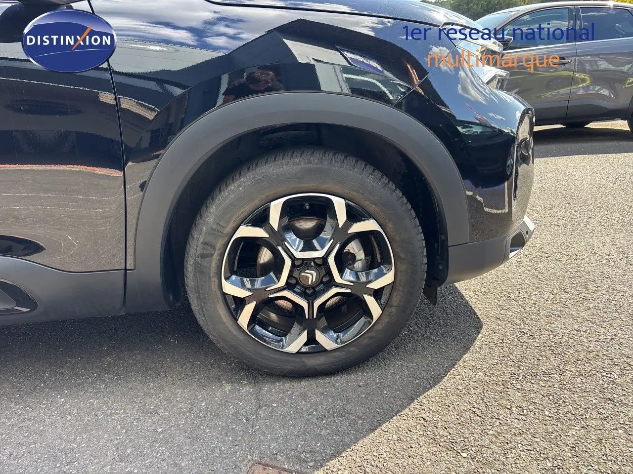 Gros plan sur la roue avant gauche du Citroën C5 Aircross noir Perla Nera, mettant en valeur la jante au design moderne.