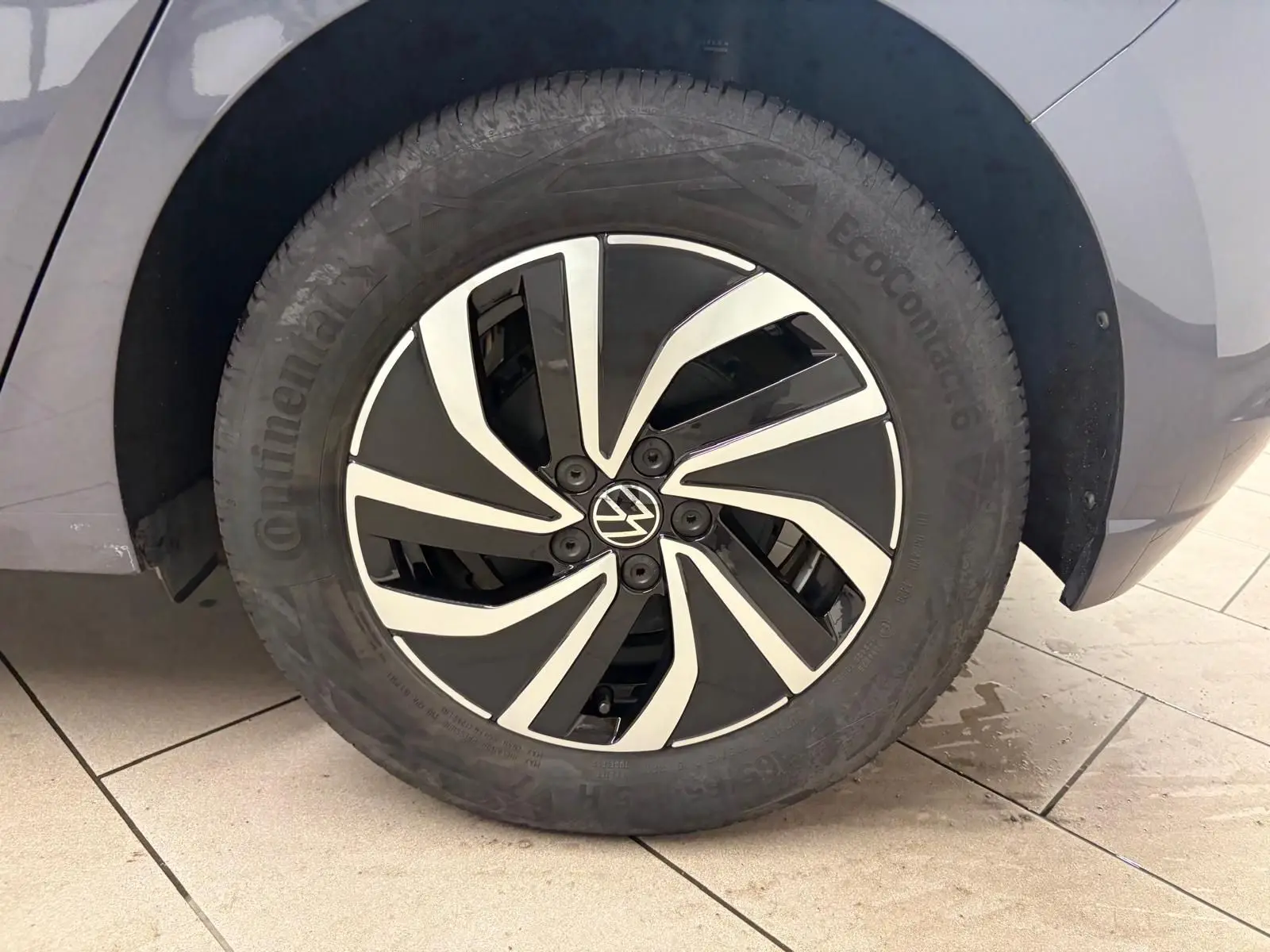 Gros plan sur la roue avant gauche d’une Volkswagen Polo gris cendre 2024 avec jante alliage bicolore distinctive.