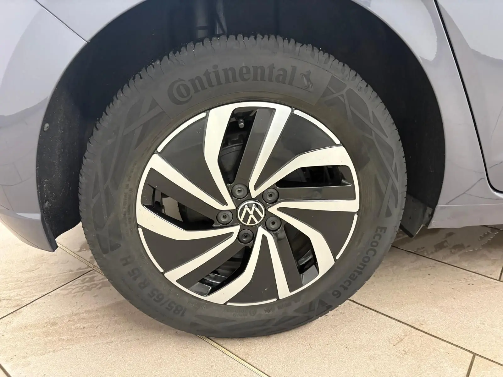 Gros plan sur la roue avant droite d'une Volkswagen Polo gris cendre 2024 avec jante alliage bicolore et pneu Continental.