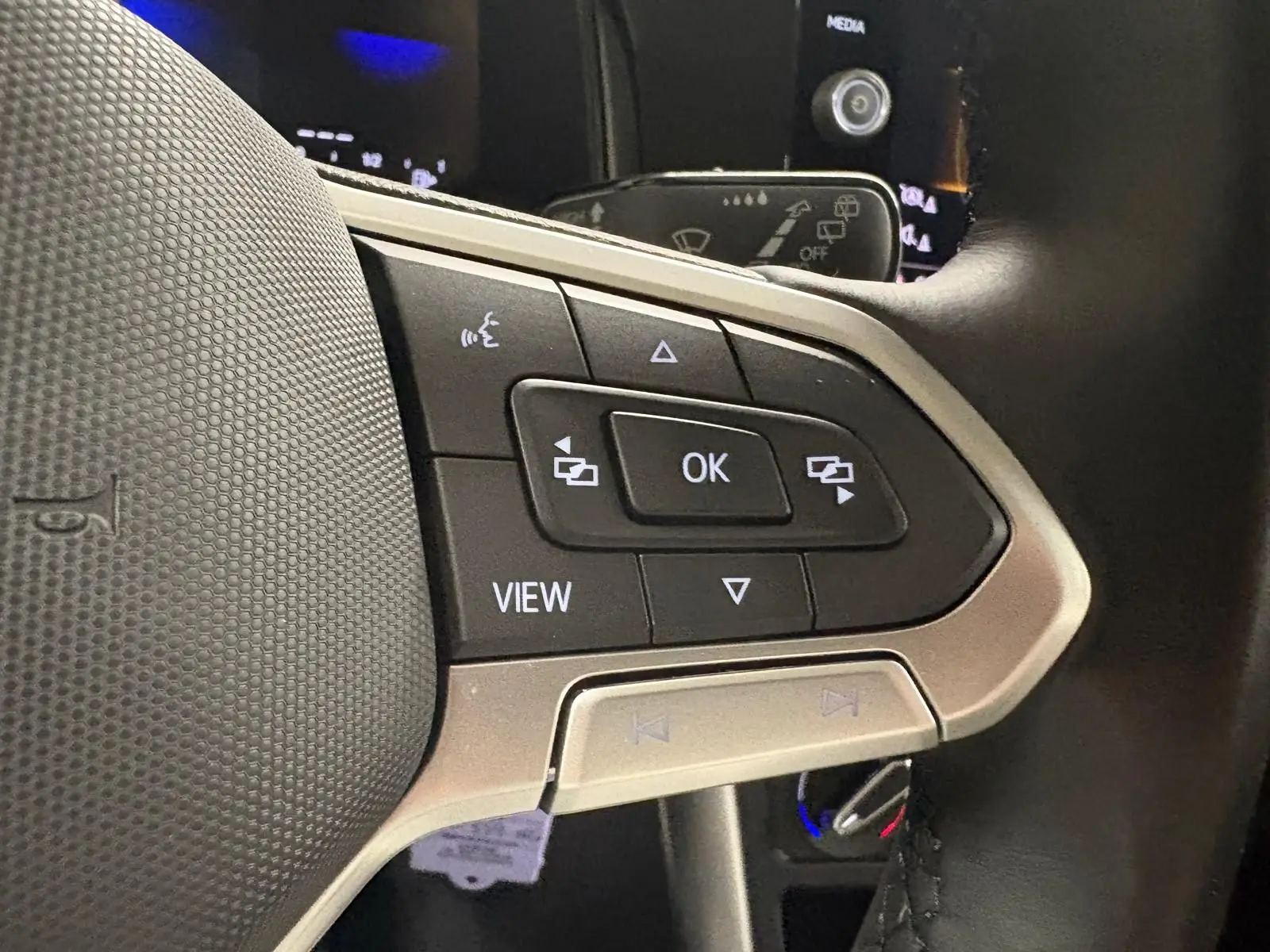 Gros plan sur les commandes multifonctions au volant de la Volkswagen Polo gris cendre 2024, version Life Plus.
