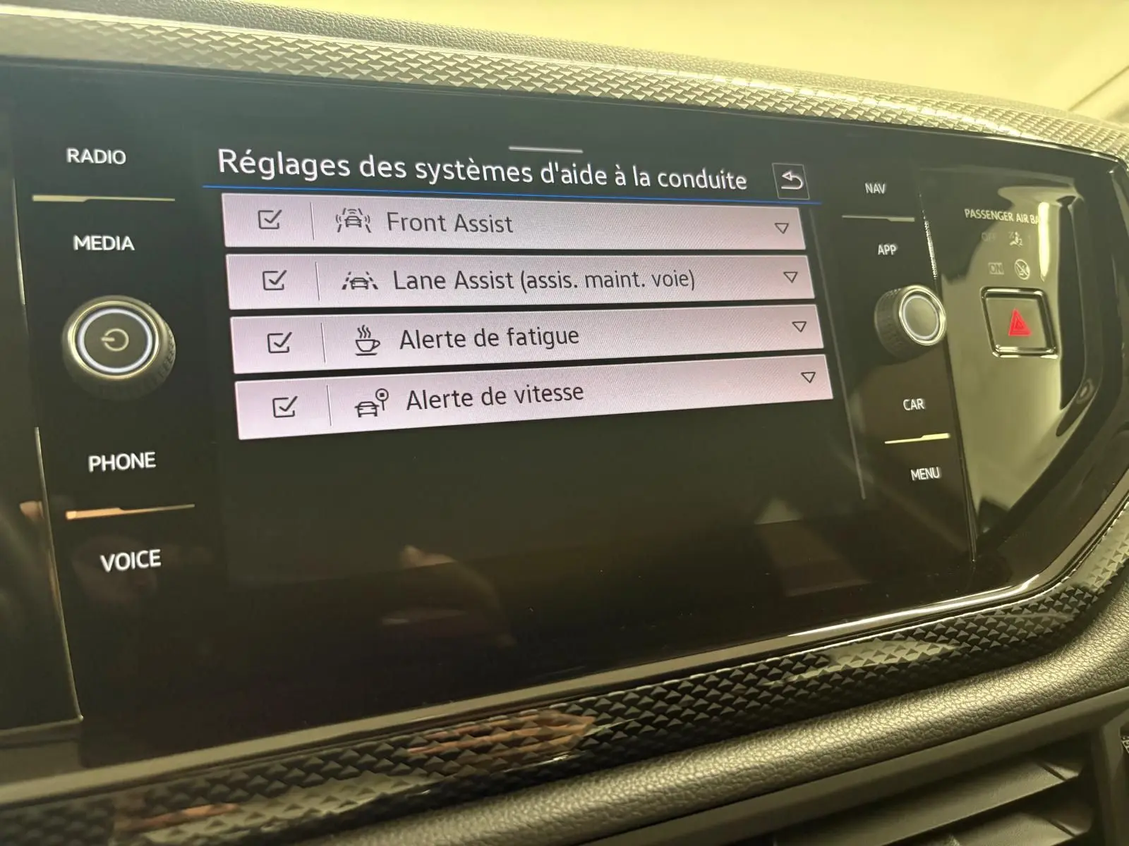 Écran central tactile de la Volkswagen Polo gris cendre 2024 affichant les réglages d’aide à la conduite.