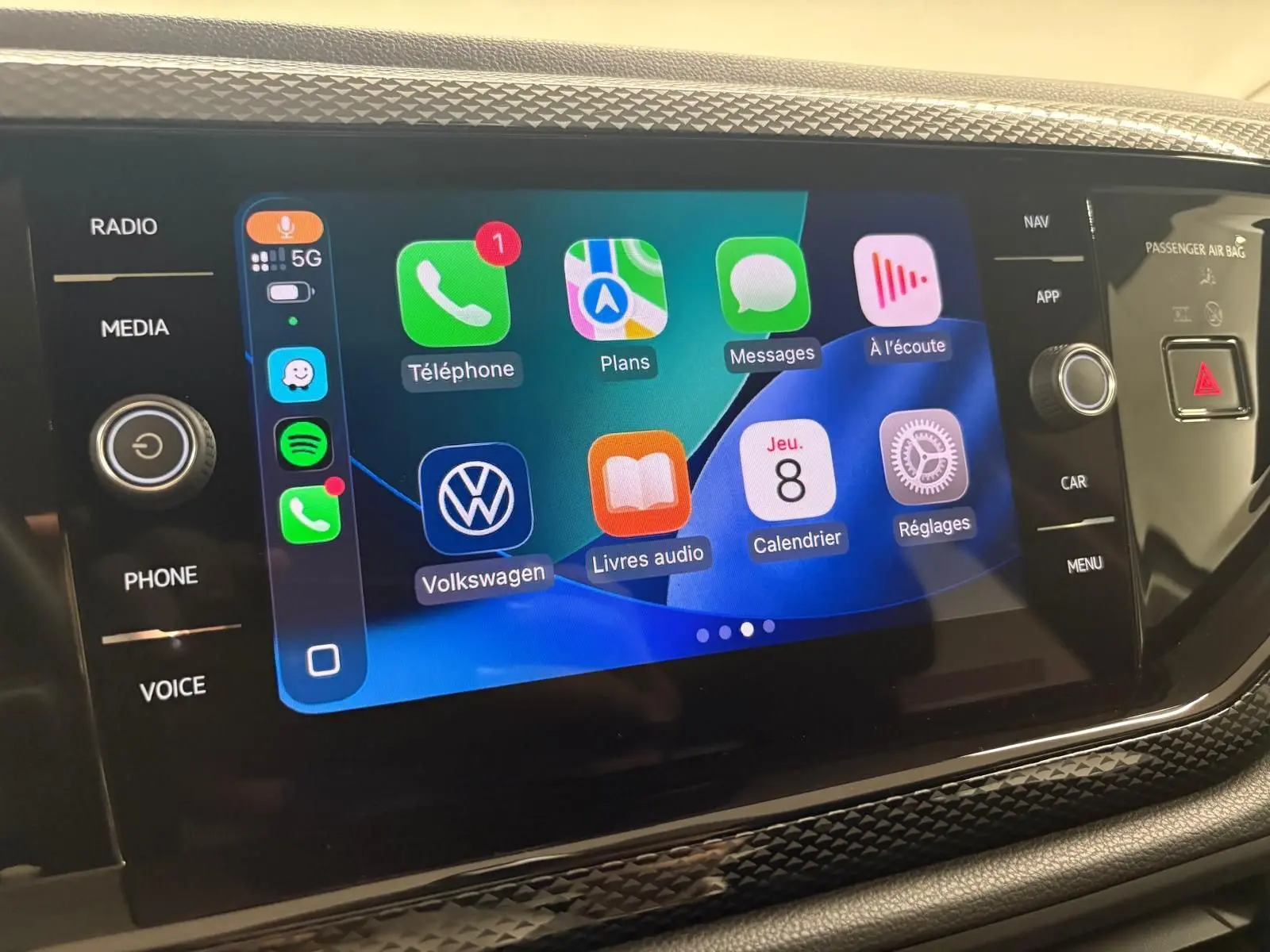 Écran tactile central de la Volkswagen Polo 2024 gris cendre, affichant des applications connectées et commandes tactiles.
