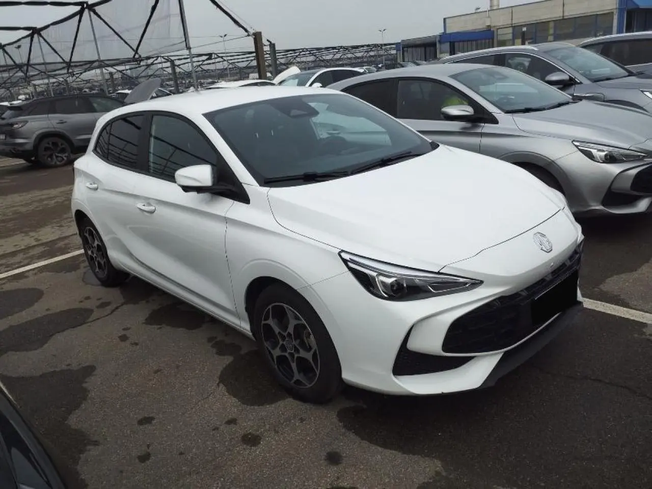 MG3 1.5 Hybrid+ 195 Luxury blanc Dover en 3/4 avant droit, avec jantes alliage et calandre noire distinctive.