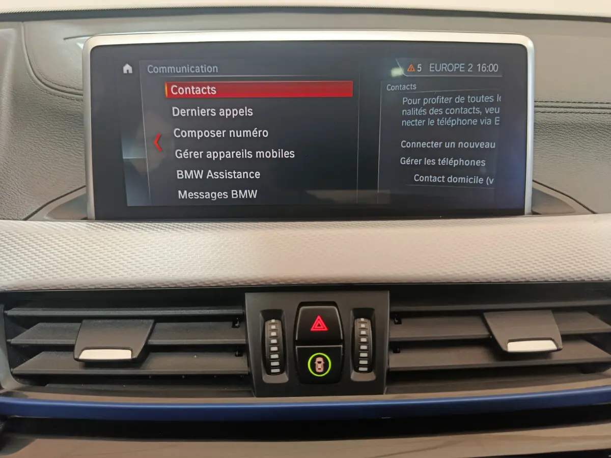 Écran tactile central affichant le menu communication dans l'habitacle beige du BMW X1 sDrive18i M Sport 2019.