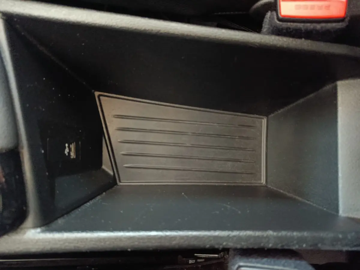 Gros plan sur le rangement intérieur noir du BMW X1 sDrive18i M Sport 2019, montrant un port USB à gauche.