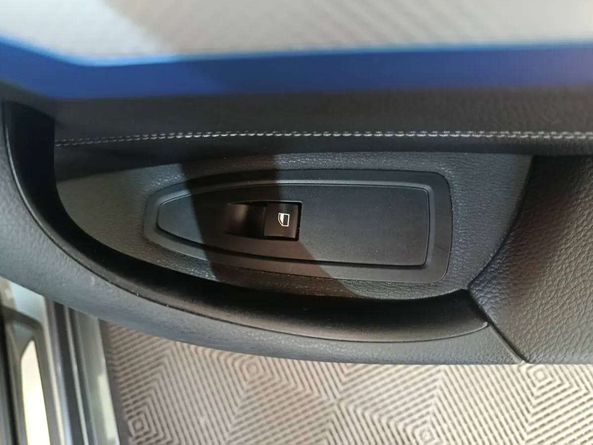 Bouton de commande de lève-vitre côté conducteur sur la portière intérieure noire d'une BMW X1 sDrive18i M Sport 2019.