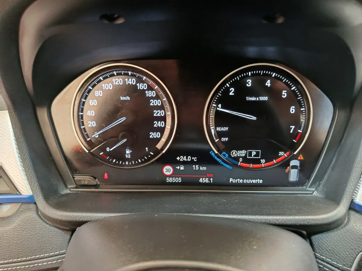 Tableau de bord numérique du BMW X1 sDrive18i 2019, affichage clair avec compte-tours et vitesse en km/h.