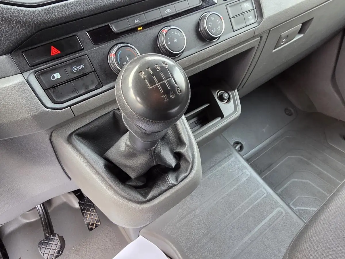 Gros plan sur le levier de vitesses manuel noir et la console centrale grise du Volkswagen Crafter Fourgon 2023.