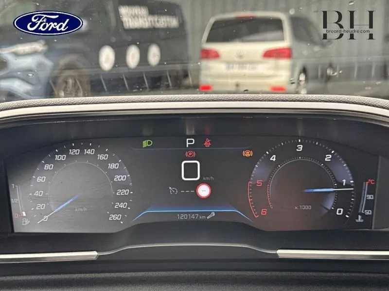Tableau de bord numérique d'une Peugeot 508 SW gris Platinium, affichant vitesse et compte-tours au repos.