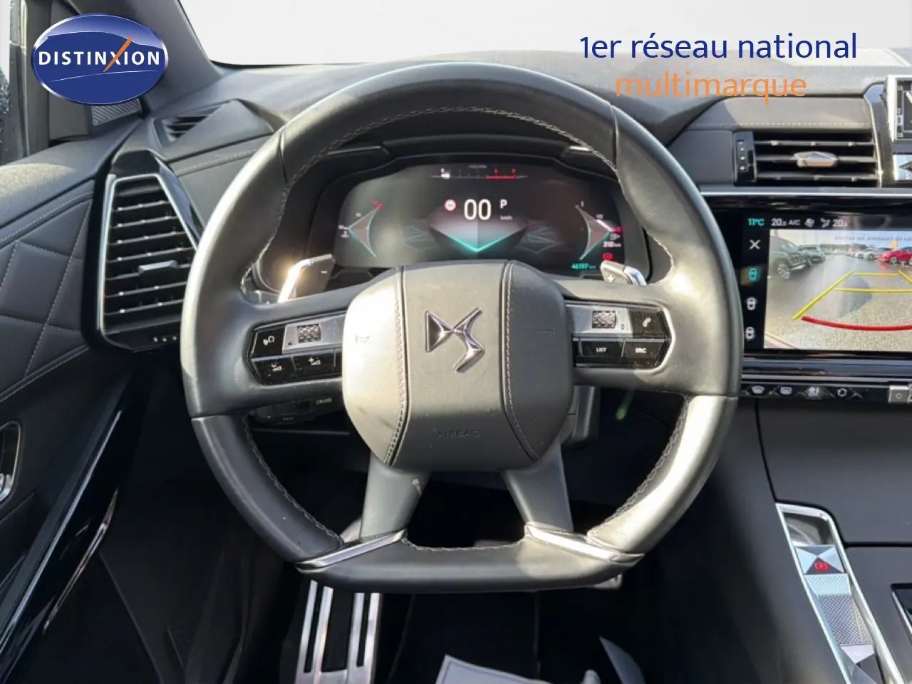 Vue rapprochée du volant cuir noir perle du DS7 2024 avec tableau de bord numérique et écran central tactile.