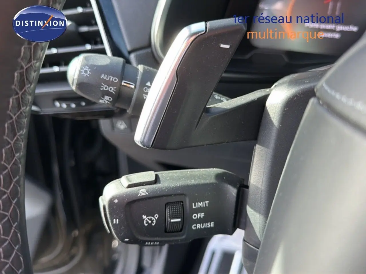 Gros plan sur la commande de régulateur de vitesse à gauche du volant du DS7 noir perle 2024.