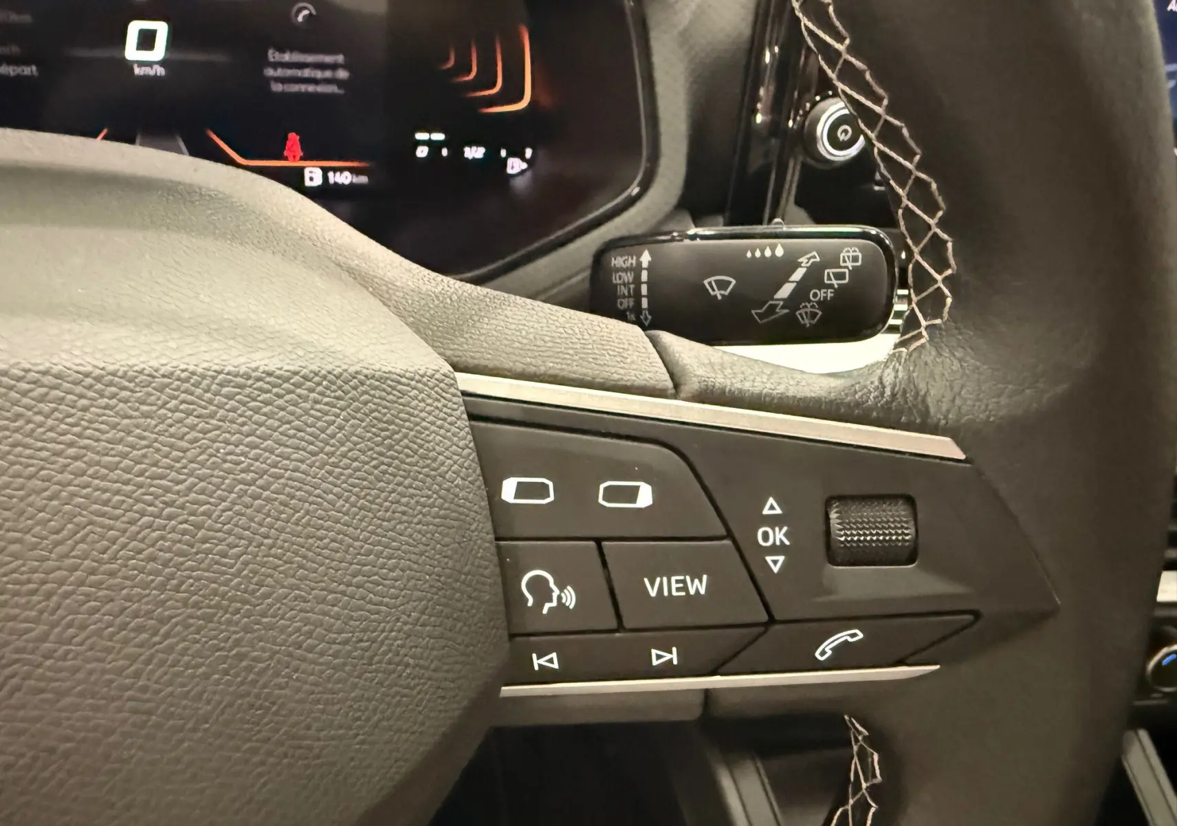 Gros plan sur les commandes multifonctions noires à droite du volant de la SEAT Ibiza 2025, avec coutures apparentes.