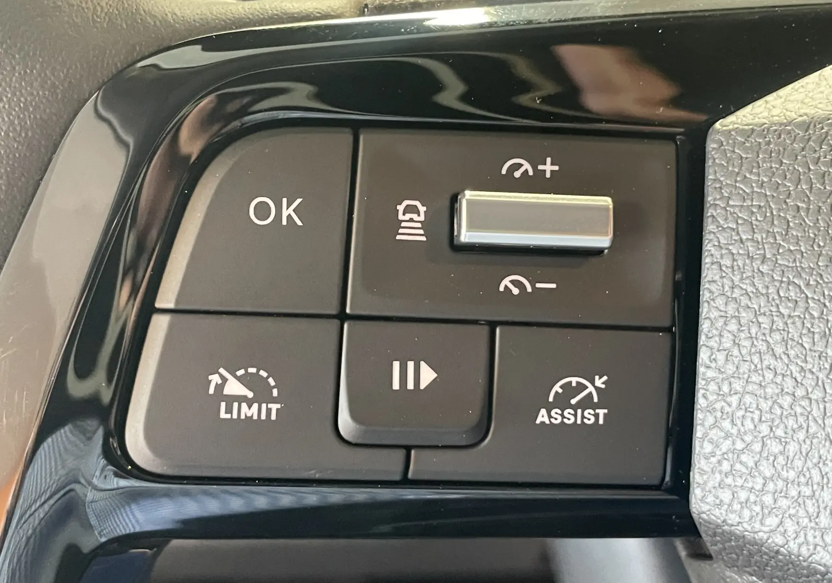 Gros plan sur les commandes du volant du Peugeot Traveller 2026, boutons noirs avec fonctions régulateur et assistances visibles.