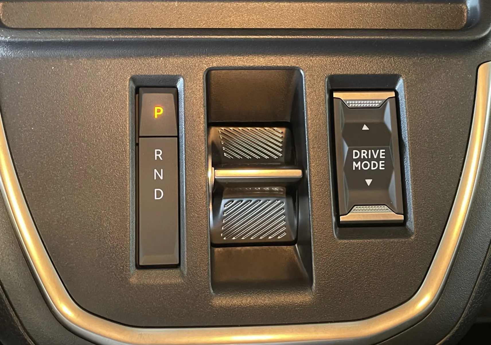 Gros plan sur la commande de boîte automatique et le sélecteur Drive Mode du Peugeot Traveller noir, intérieur moderne.