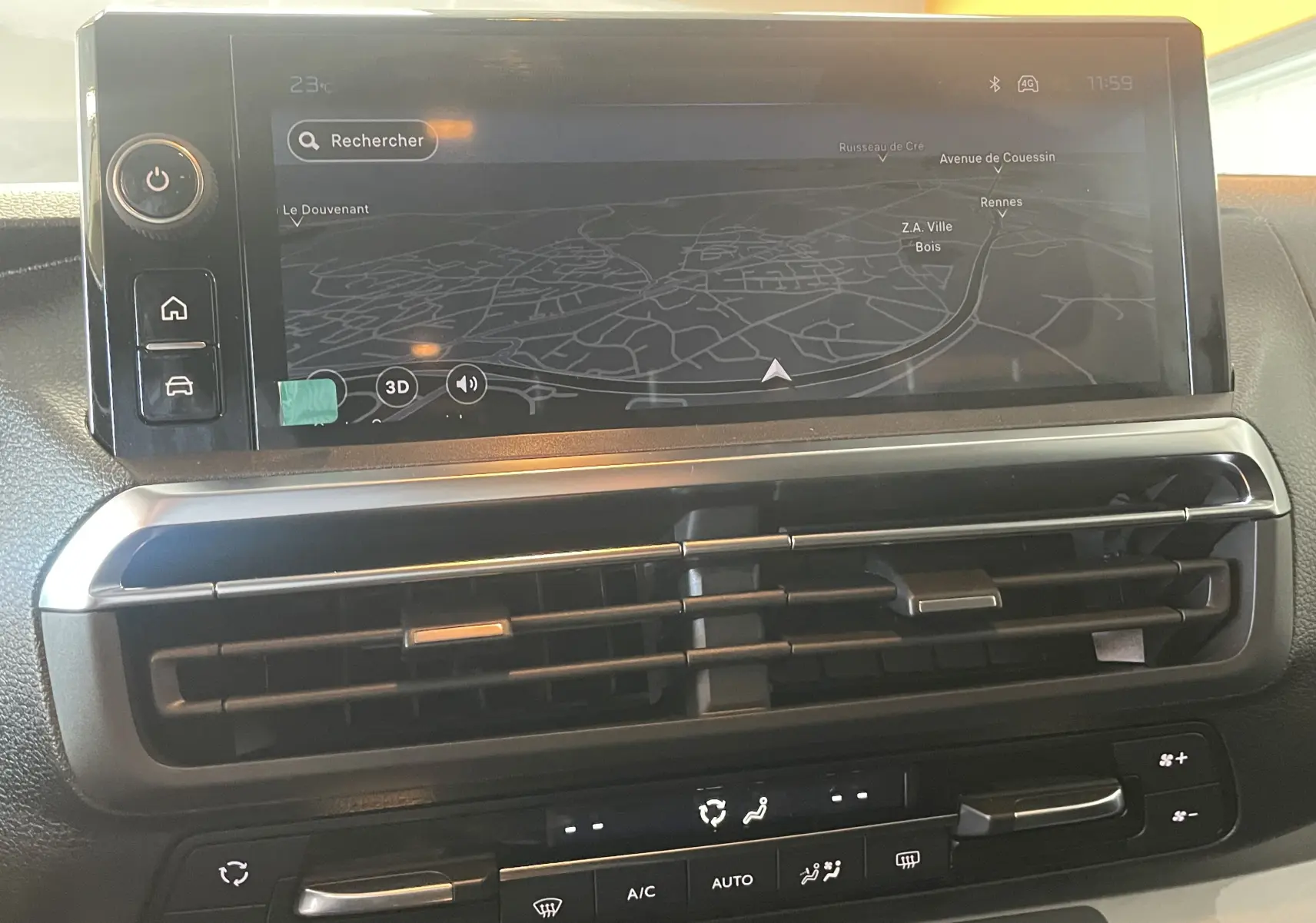 Vue rapprochée de l’écran tactile central noir du Peugeot Traveller 2026 avec navigation et commandes de climatisation.