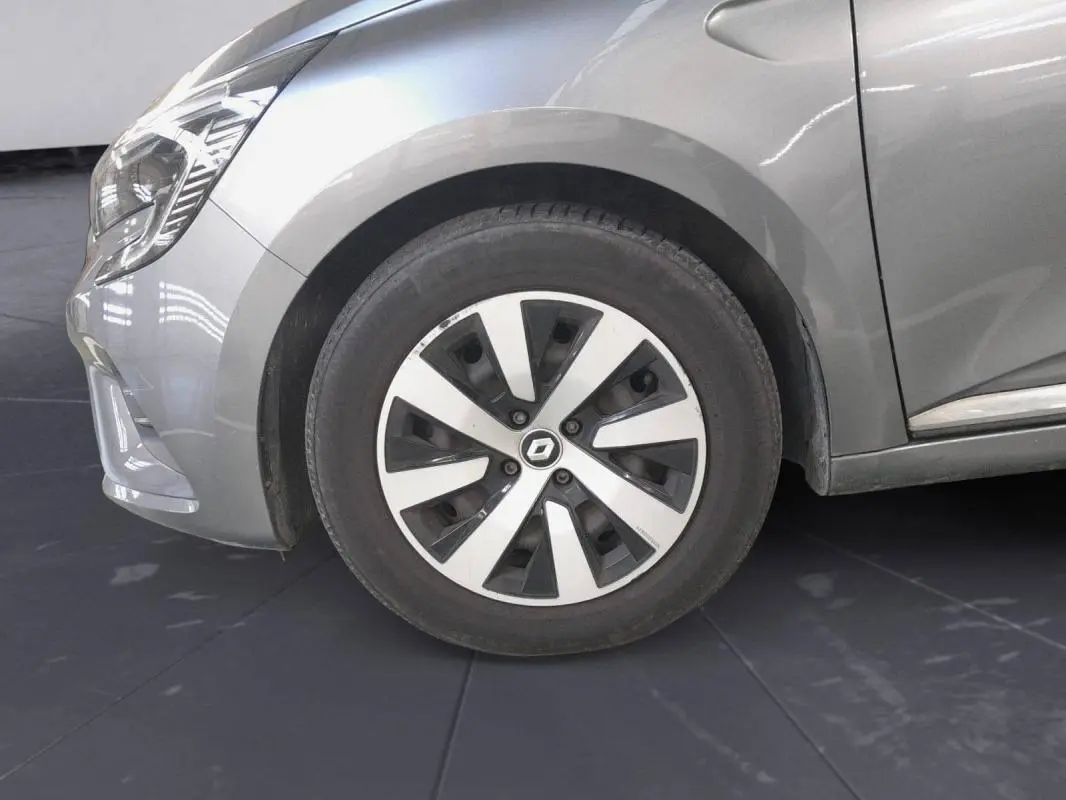 Vue de profil avant gauche sur la roue et l'aile d'une Renault Clio gris clair 2023 avec jantes alliage 16 pouces.