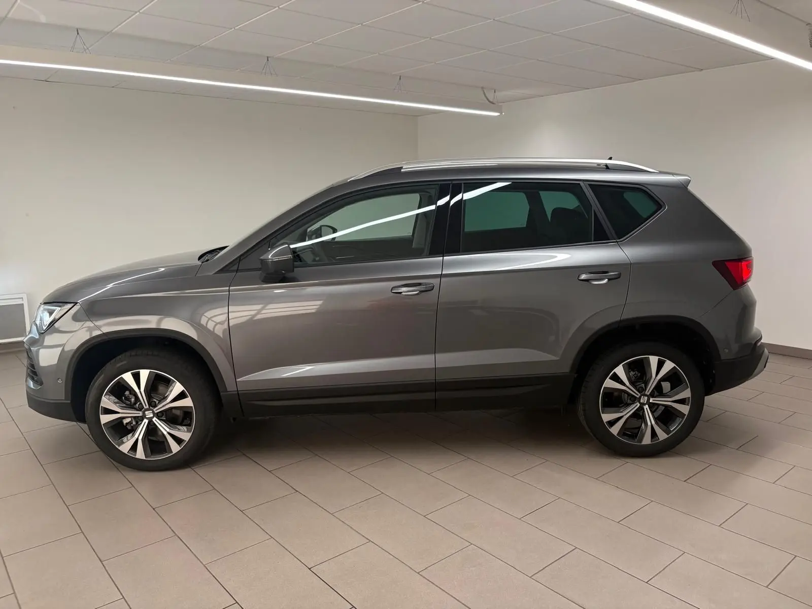 Profil droit du SEAT Ateca 2.0 TDI 150 DSG7 COPA en gris graphite métallisé avec jantes alliage 18'' usinées.