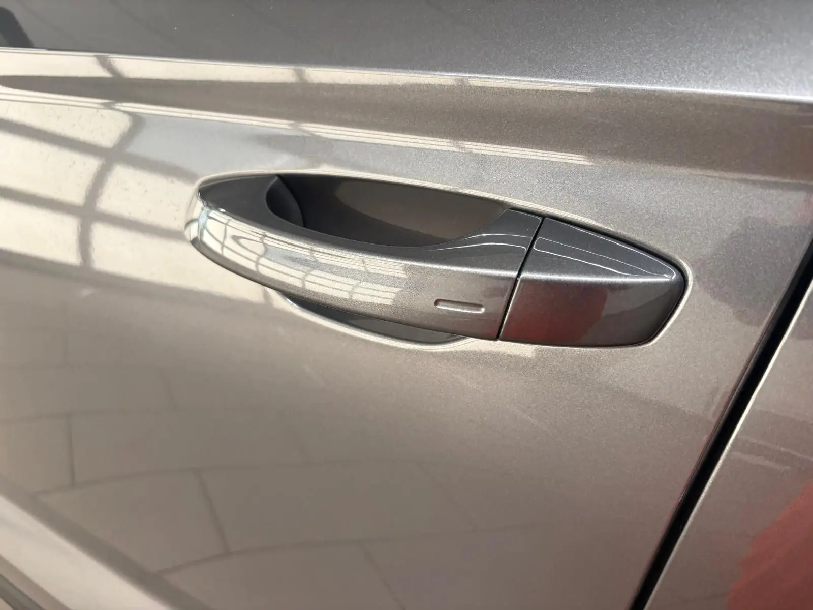 Poignée de porte côté gauche du SEAT Ateca 2025 gris graphite avec finition métallisée brillante.