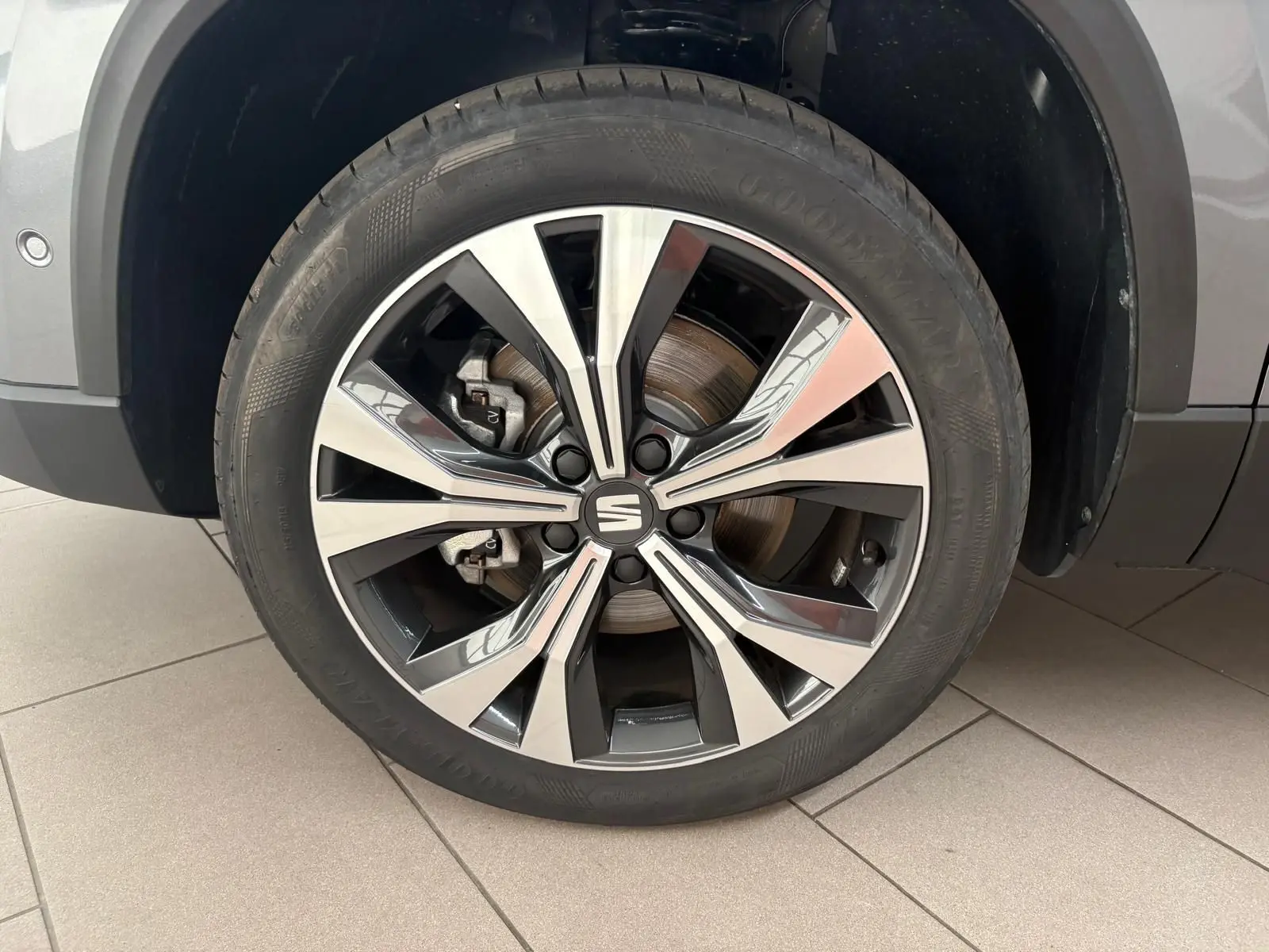 Gros plan sur la jante alliage 18'' usinée du SEAT Ateca gris graphite, avec pneu Goodyear visible.