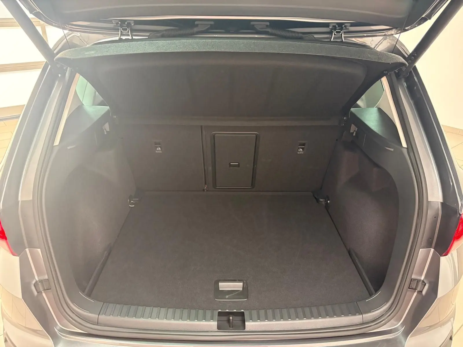 Coffre ouvert vu de l'arrière d'un SEAT Ateca 2.0 TDI Gris Graphite avec hayon électrique mains-libres.
