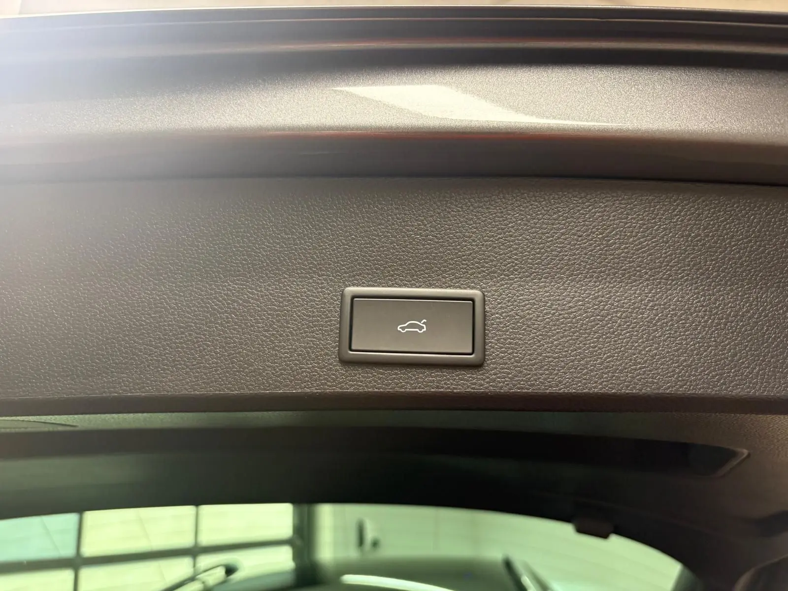 Bouton d'ouverture électrique du hayon sur la partie intérieure du coffre du SEAT Ateca gris graphite, vue rapprochée.