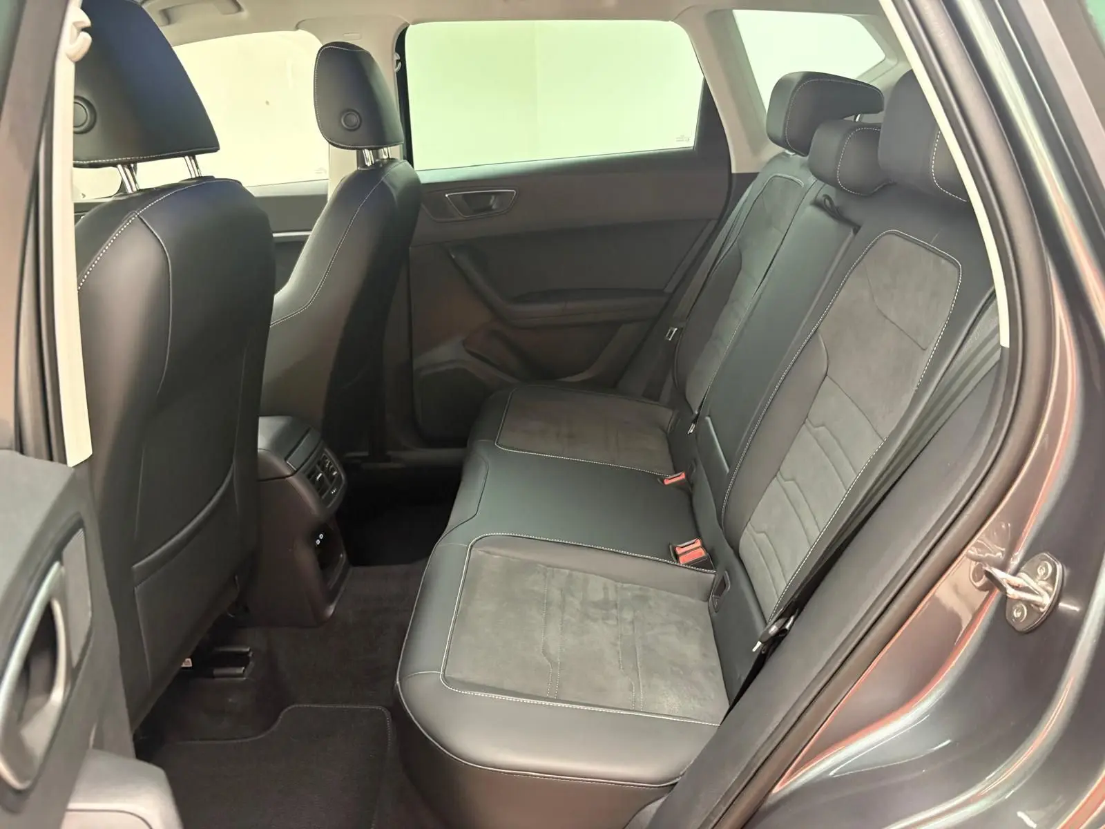 Vue intérieure côté arrière droit du SEAT Ateca gris graphite, montrant les sièges arrière en cuir et alcantara.