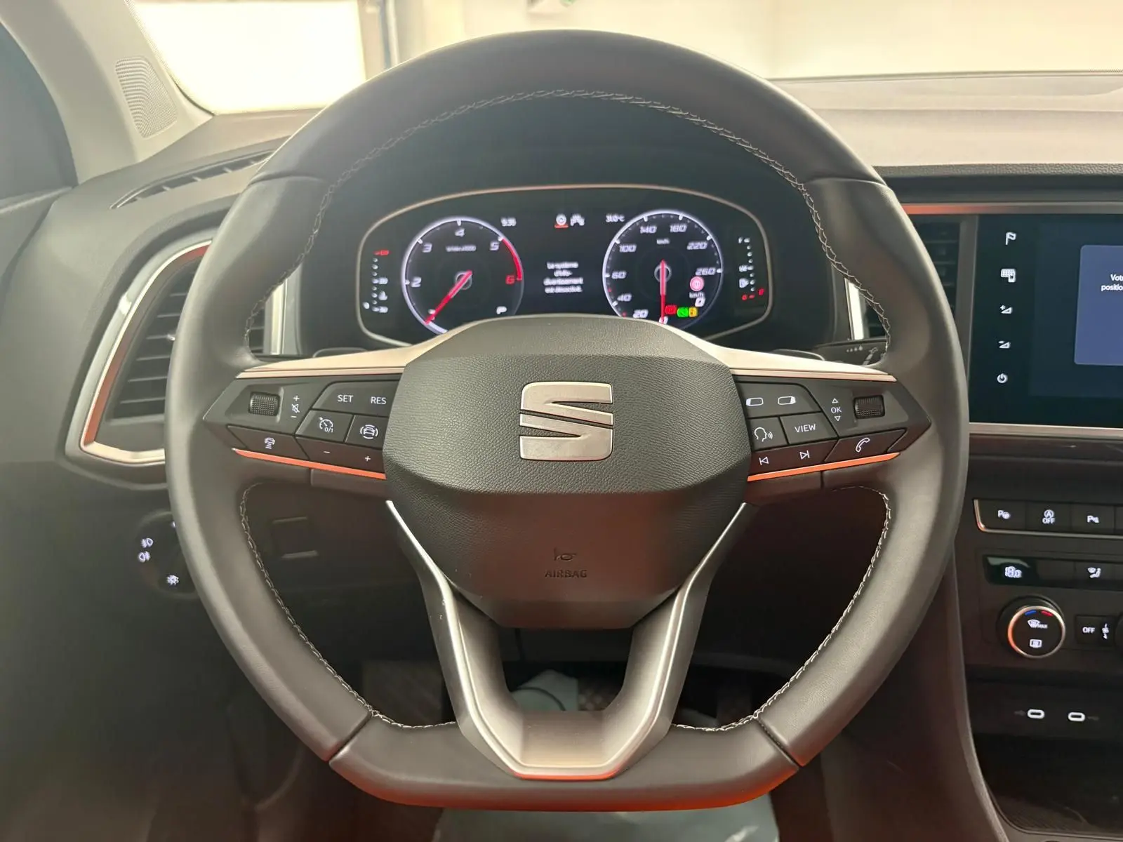 Vue rapprochée du volant noir du SEAT Ateca 2.0 TDI 150 DSG7 Copa avec tableau de bord numérique allumé.